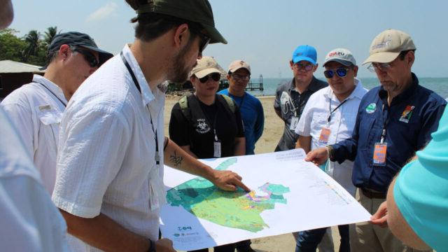 A small group of people, including municipal officials, review a land-use planning map